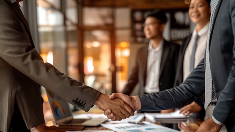alt="Two people are shaking hands"